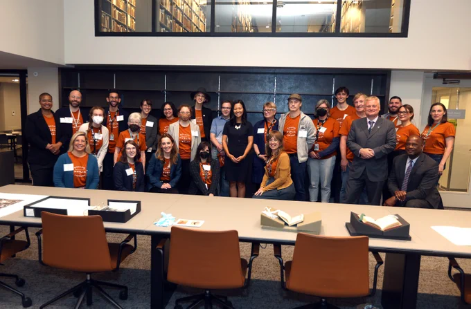 Mayor Wu poses with BPL staff and leadership, many wearing orange t-shirts that say "Boston Public Library."