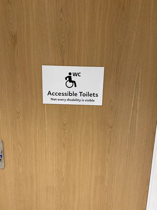 Sign on a toilet door explaining that not every disability is visible