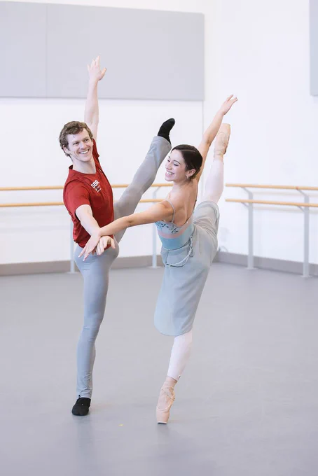 Jonathan Hanks and Alessandra Bramante in rehearsal for The Little Mermaid. Both dancers are balancing on one leg with their other leg outstretched in the air. Photo Emily Nuttall.
