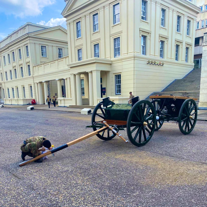 A young soldier with a bottle of polish and a rag prepares that Gun carriage that will carry the Queen. Outside Wellington Barracks.
