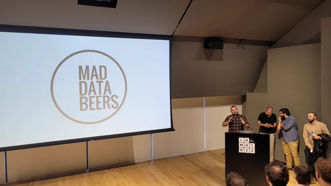 Pantalla de auditorio con el logo de Databeers Madrid y los organizadores hablando.