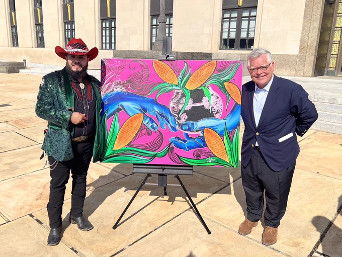 Artist Jose Vera Gonzalez gifts Mayor Cooper a painting. The two blue hands represents Nashville embracing the Hispanic community.