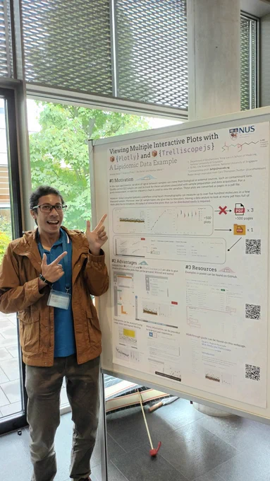 Jeremy Selva pointing to a poster titled: Viewing Multiple Interactive Plots with 📦 {Plotly} and 📦 {Trelliscopejs}: A Lipidomic Data Example