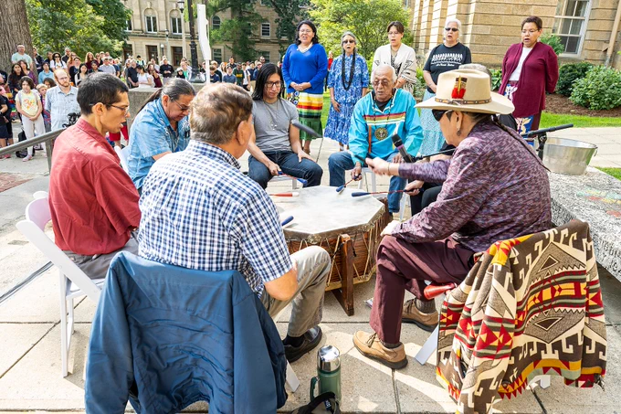 Members of the Wisconsin Dells Singers perform in a drum circle during the flag-raising ceremony.