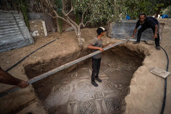 Workers clean the area around a rare Byzantine-era mosaic floor recently discovered by a farmer in the Gaza Strip.(Fatima Shbair / Associated Press)