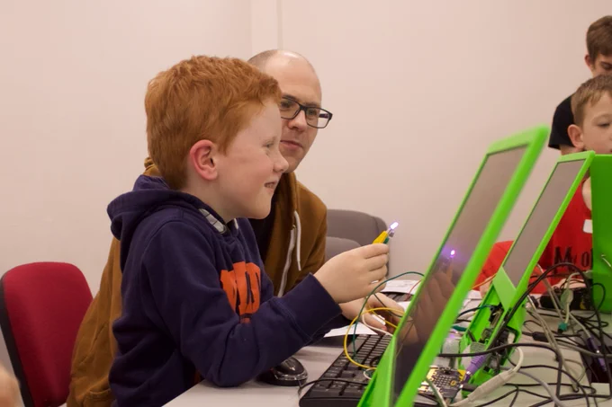 Young attendee with parent coding an LED to flash on and off