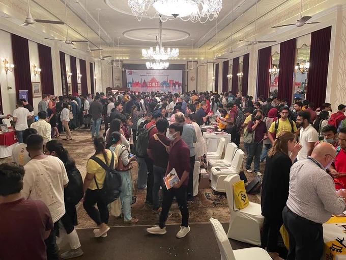 Attendees visit tables at a student fair in Delhi, India
