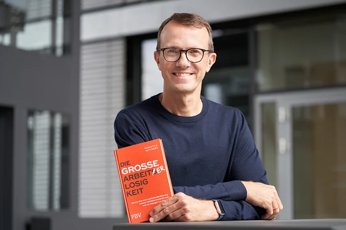 StepStone CEO Sebastian Dettmers mit seinem Buch "Die große Arbeiterlosigkeit" in der Hand