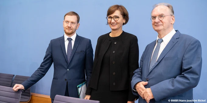 Ministerpräsident Michael Kretschmer, Bundesbildungsministerin Bettina Stark-Watzinger und Ministerpräsident Reiner Haseloff stehen in der Bundespressekonferenz. Foto: BMBF/Hans-Joachim Rickel