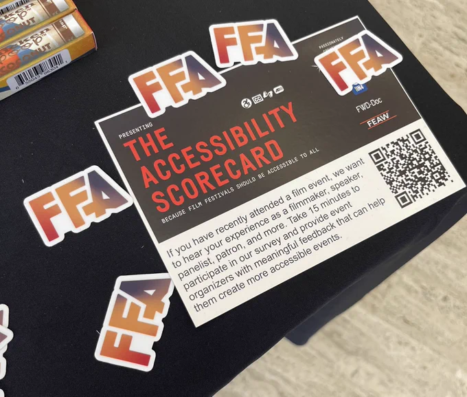 Image of FFA stickers and a postcard reading “the accessibility scorecard” on a table