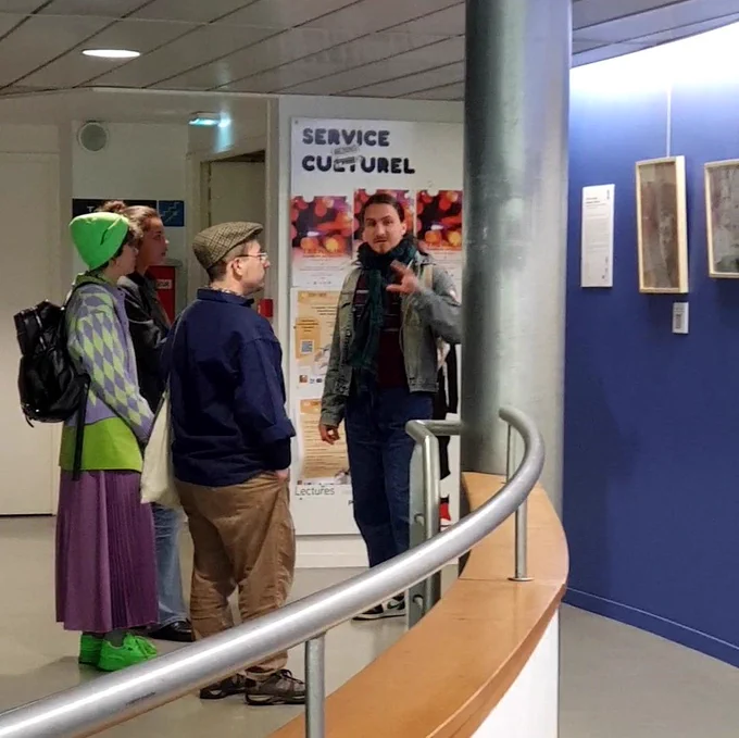 Sacha Kalcina présente l'exposition à un groupe de visiteurs