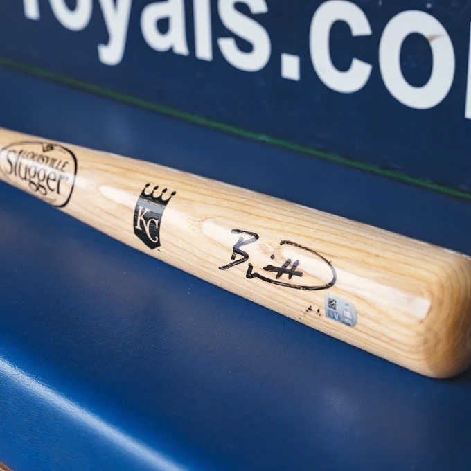 A photo of a signed Bobby Witt Jr. bat in the Royals dugout.