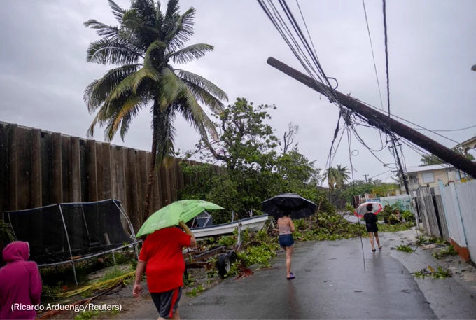 People are caught in a downpour from Hurricane Fiona in Peñuelas, Puerto Rico, on Sunday. (Ricardo Arduengo/Reuters)