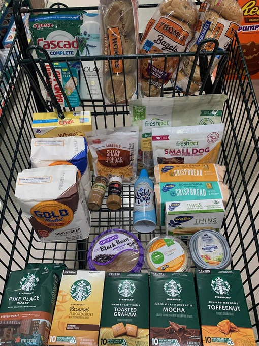 Very organized grocery cart filled with coffee and carb-filled foods.