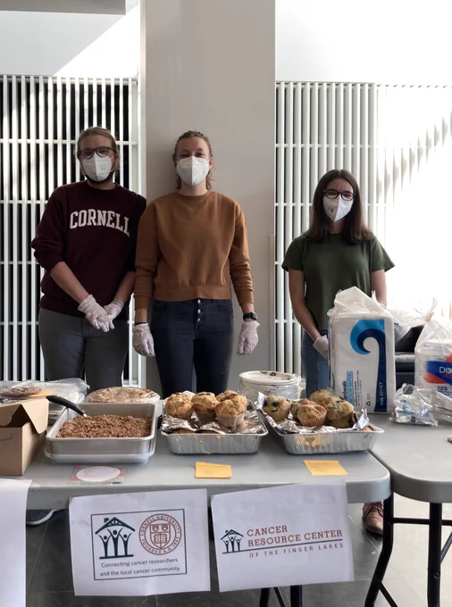 Fischbach and Lammerding lab members standing at a table with an assortment of delicious baked goods