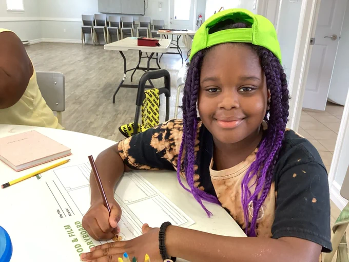 Child sitting at a table and working on a "Food and Film Storyboarding" activity.