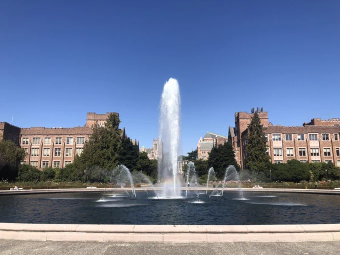 Fountain in front of two academic buildings under a blue sky