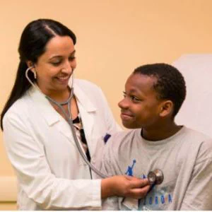 Physician using stethoscope and adolescent patient