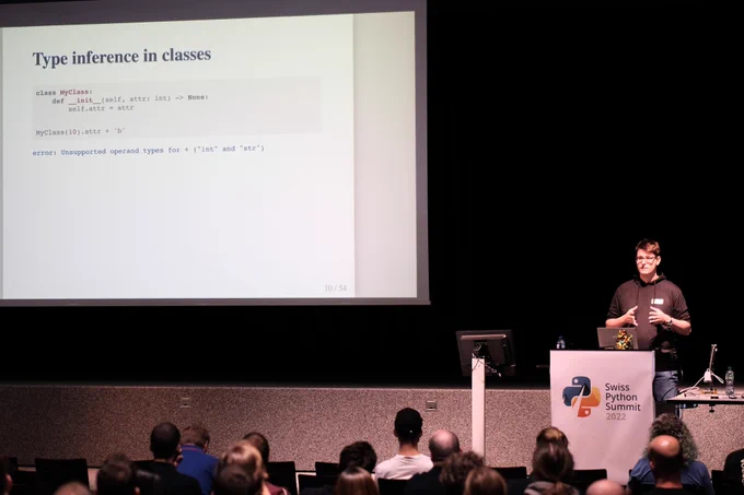 Photo by @dbrgn of conference speaker presenting "Type interference in classes" for the Python programming language