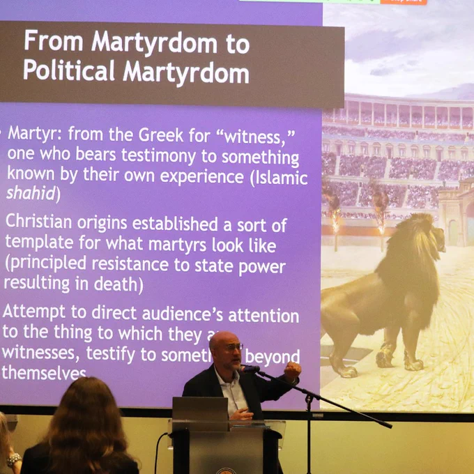 Photo of Andrew Murphy, Ph.D. gesturing to his presentation during the lecture