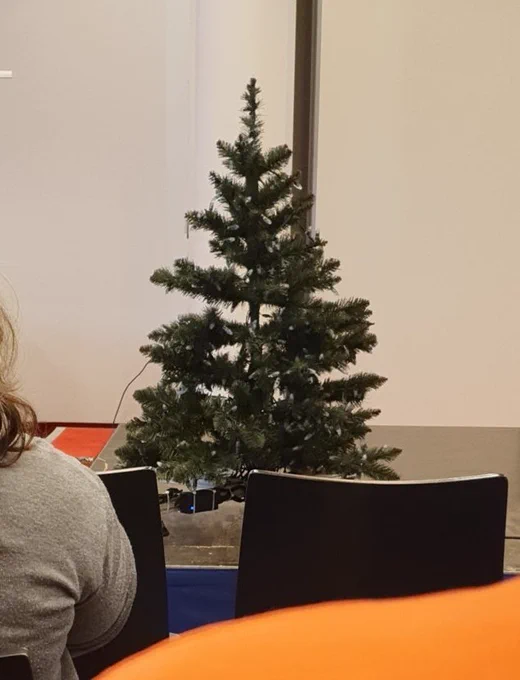Ein kleiner Tannenbaum mit Lichterkette auf einer Bühne