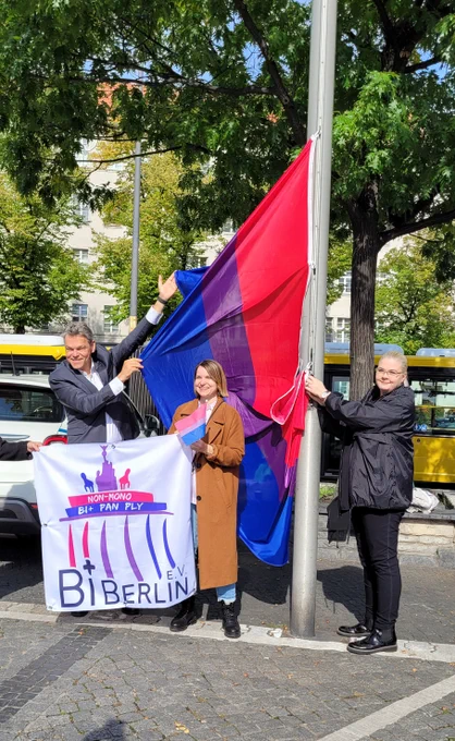 Der Bezirksbürgermeister hisst zusammen mit einer Frau die Bi-Flagge