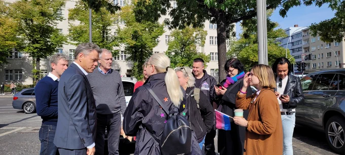 Gruppe von Menschen steht vor dem Rathaus Schöneberg zur Hissung der Bi-Flagge