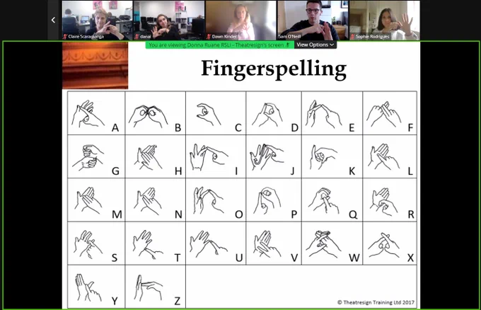 The Scaramanga team learning how to fingerspell.