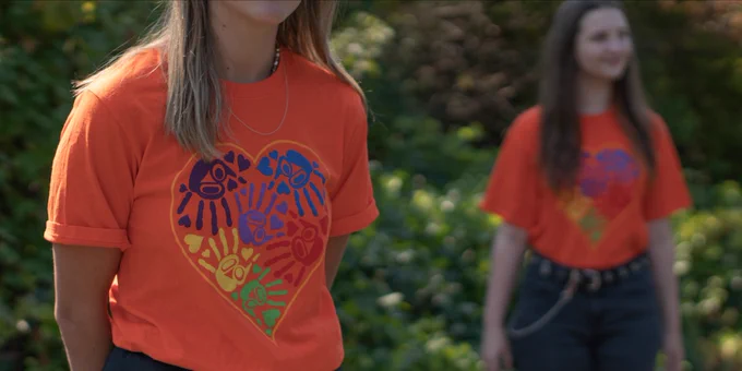 Two UVic students standing in their Orange Shirt Day t-shirts
