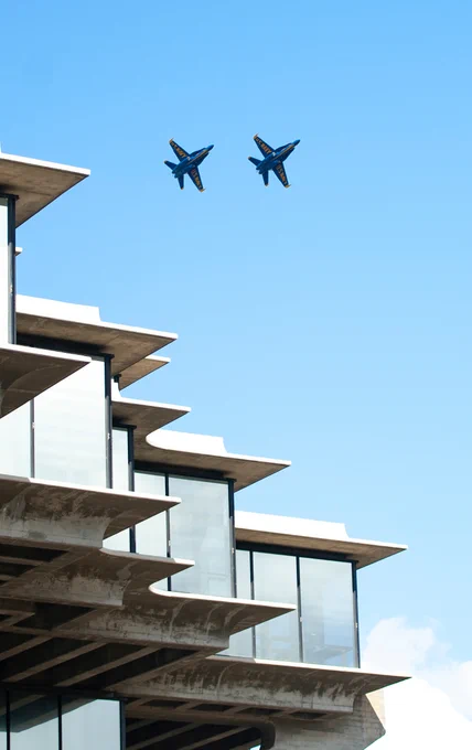 Two Blue Angel airplanes flying over Geisel Library