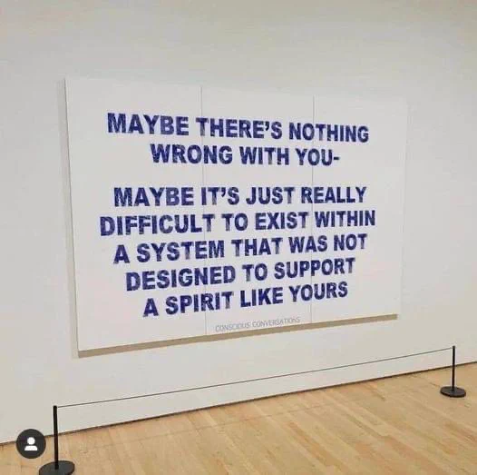 Sign on a wall that reads “Maybe there’s nothing wrong with you. Maybe it’s just really difficult to exist within a system that was not designed to support a spirit like yours.”