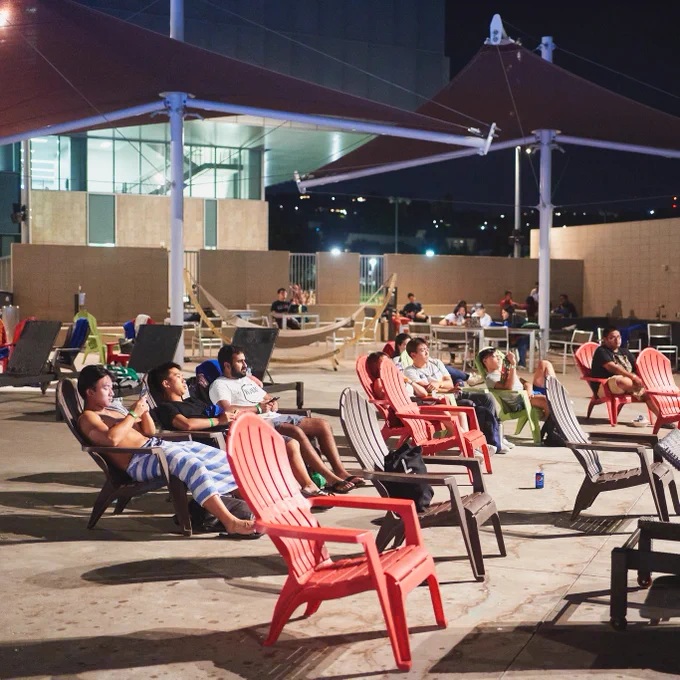 Students seated on lounge chairs while watching a movie.