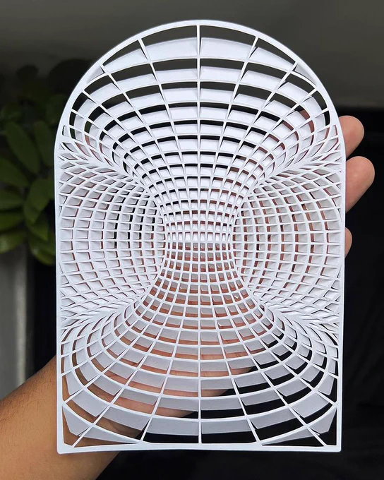 all-white op art paper cutting displayed on vertical open palm