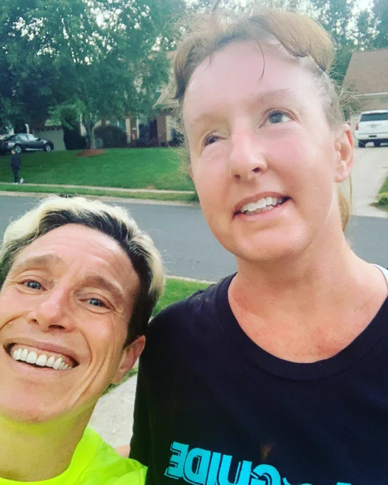 Julie and Amy are smiling and taking a selfie wearing Para Guide shirts in the driveway