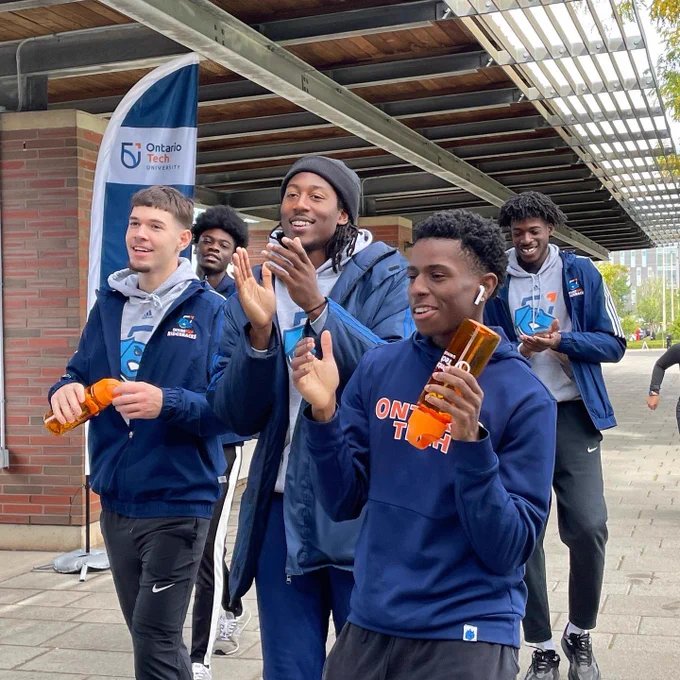 Members of the basketball team cheer as they cross the finish line