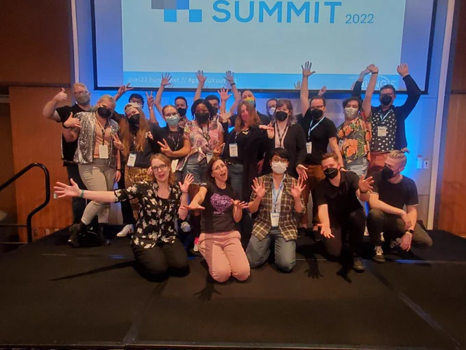 Group photo of many Game UX summit speakers and staff, most of them being masked and waving happily.