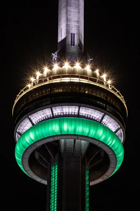 Closeup of the CN Tower at night lit in green and white / Gros plan de la Tour CN la nuit, éclairée en vert et blanc