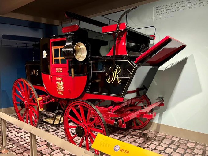 Image shows one of the old, red, Royal mail carriages. On the door above the Royal crest are the words 'Bristol, London'.