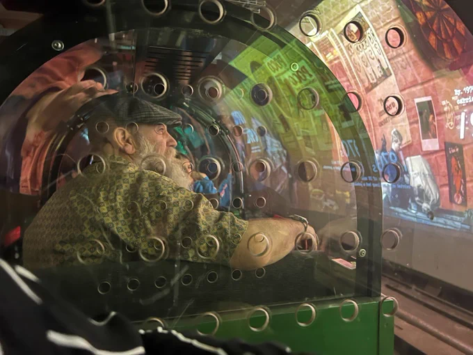 Image shows one of the attendees on the Mail Rail ride. He is looking at the displays being projected onto the walls of the tunnel.