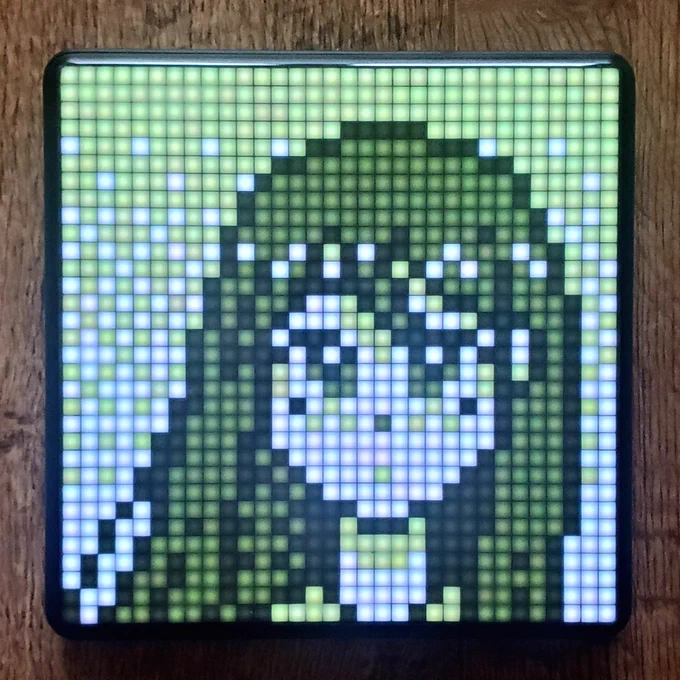PXL LED display mounted on dark wood.