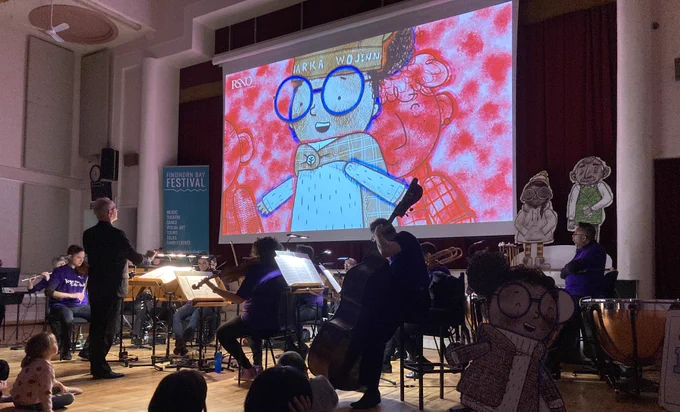 Members of the Royal Scottish National Orchestra at a packed Forres Town Hall for their performance of Yoyo and the Little Auk. A large screen projects the story, so beautifully articulated with music.