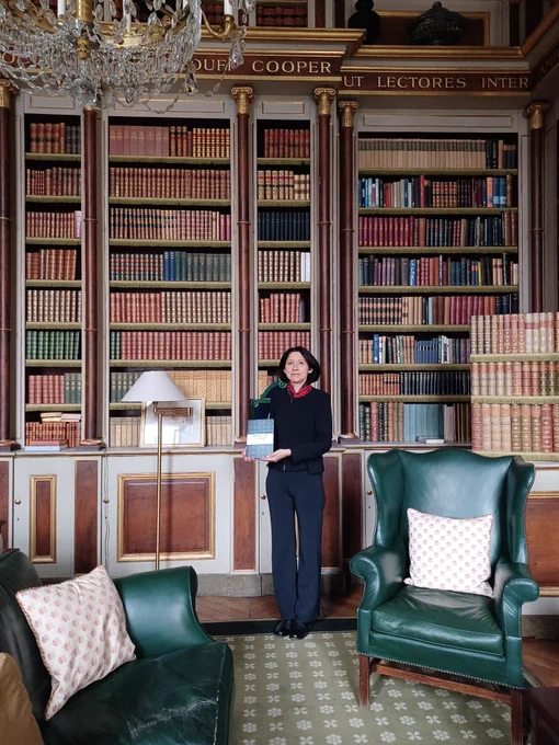 Dr Rogelia Pastor-Castro in the Duff Cooper library at the British ambassador's residence in Paris holding a copy of the book 'Embassies in Crisis'