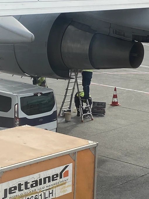 Repair crew exchanging a valve on an airplane engine.