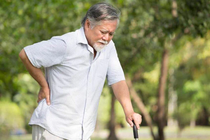 Older gentleman going for a walk while suffering from bulging disc and herniated disc in his spine.