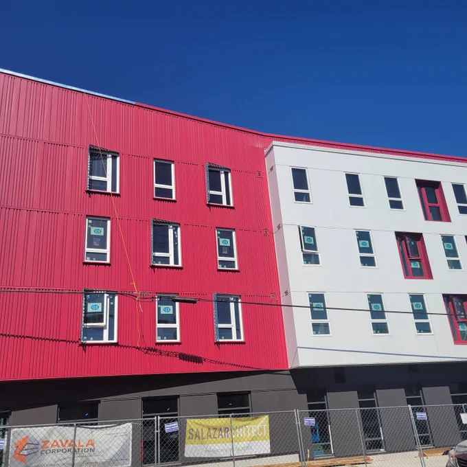 Image of Las Adelitas - four story building, pink and white, with windows - still under construction