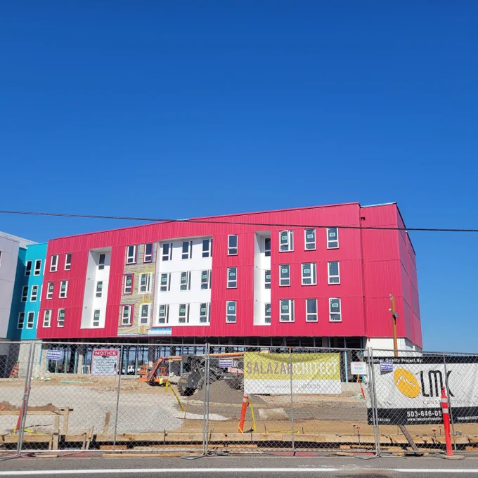 Image of Las Adelitas - four story building, pink and white, with windows - still under construction