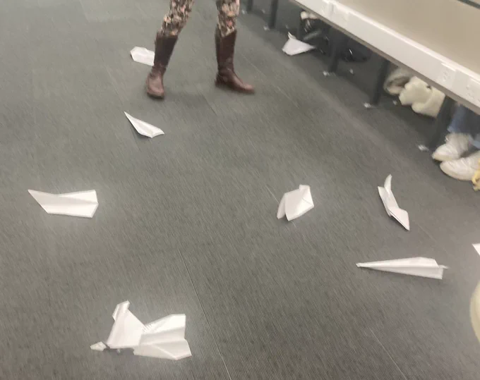 Paper airplanes on the floor of a lecture theatre