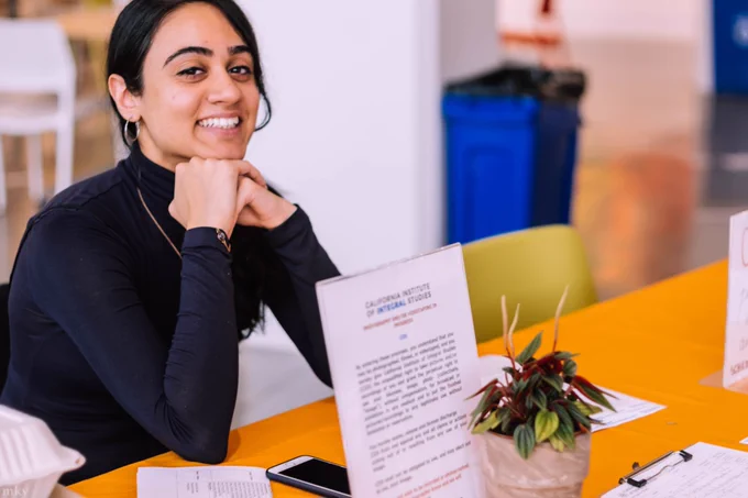 CIIS Open House where a person is ready to greet you at a table