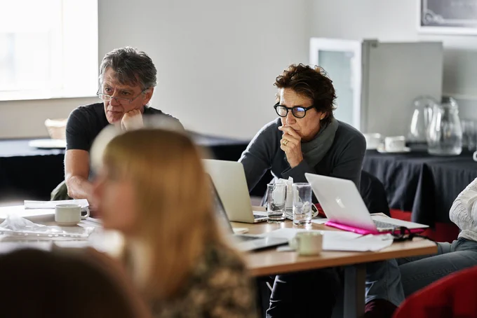 People sitting together on desks in a room, looking at their laptops. Image: Pete Martin Photography.