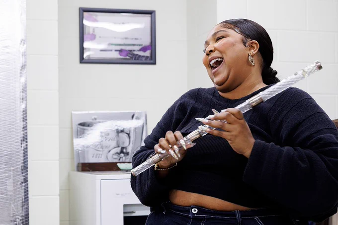 Lizzo laughs while holding a crystal flute in the Library of Congress flute vault on Monday, September 26, 2022. Photo by Shawn Miller.
